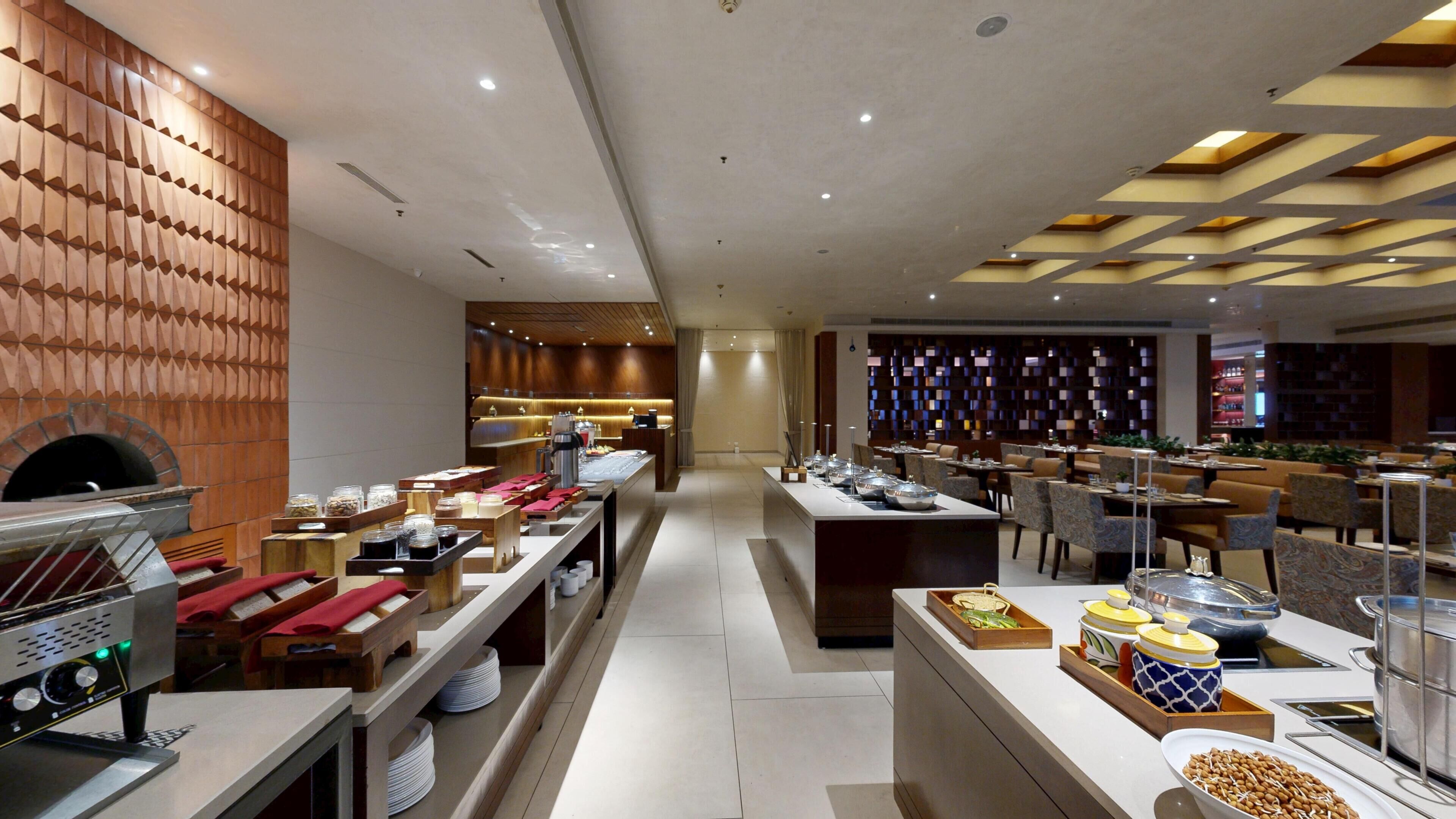 Un desayuno buffet moderno con diversas opciones de comida y una máquina de café.