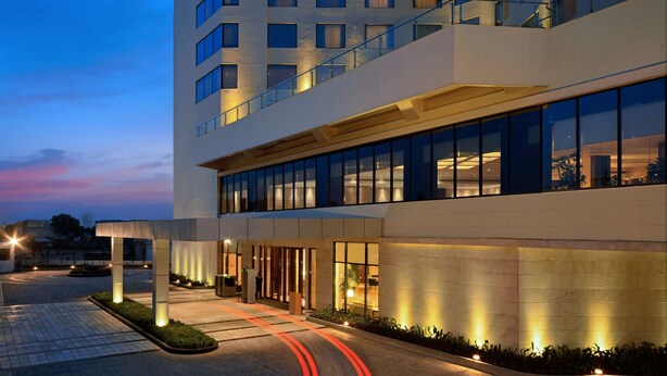A modern hotel with a spacious entrance, large windows, and a well-lit outdoor area.