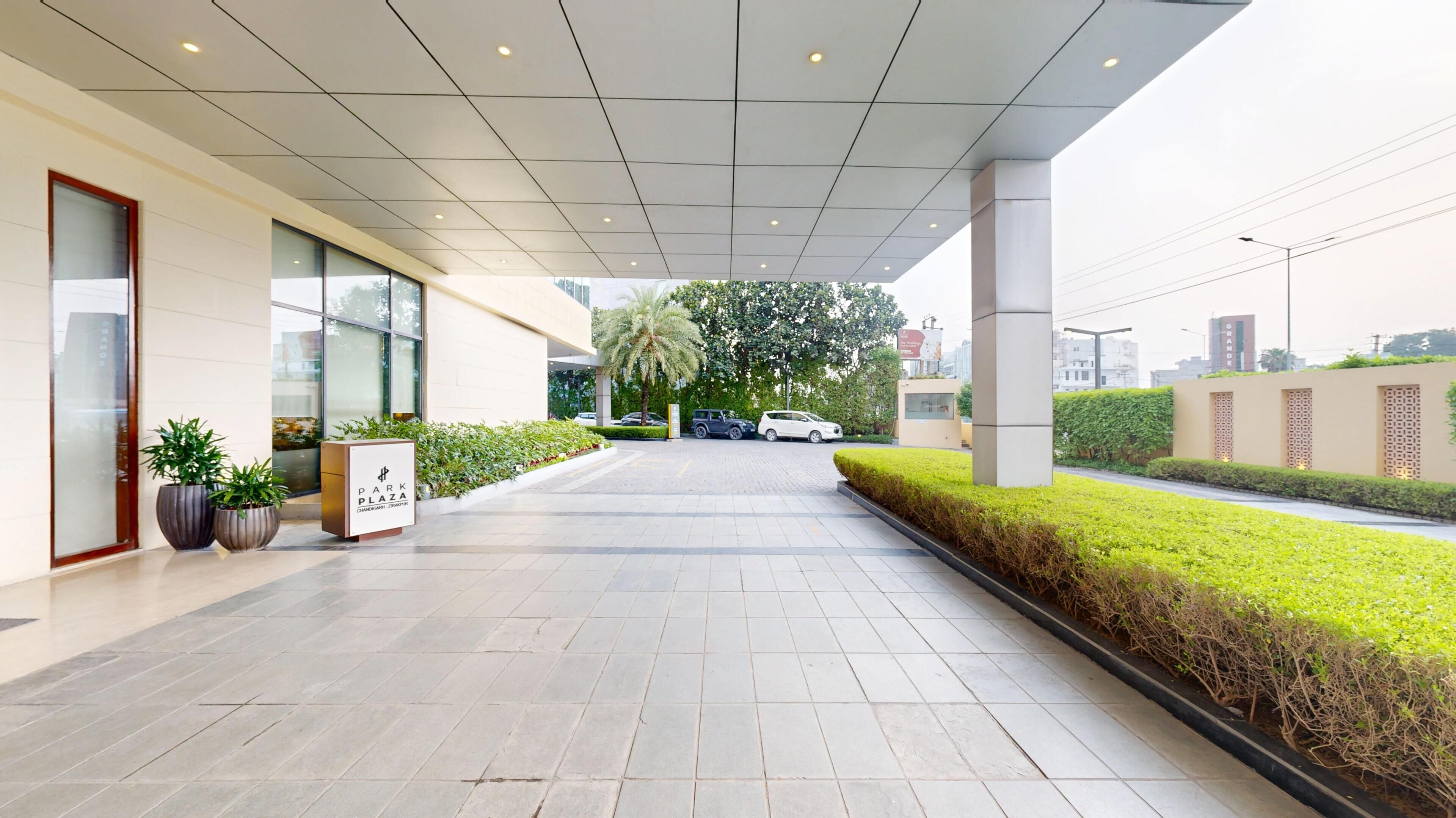 A covered walkway leading to a building with a sign reading 'PARK PLAZA.'