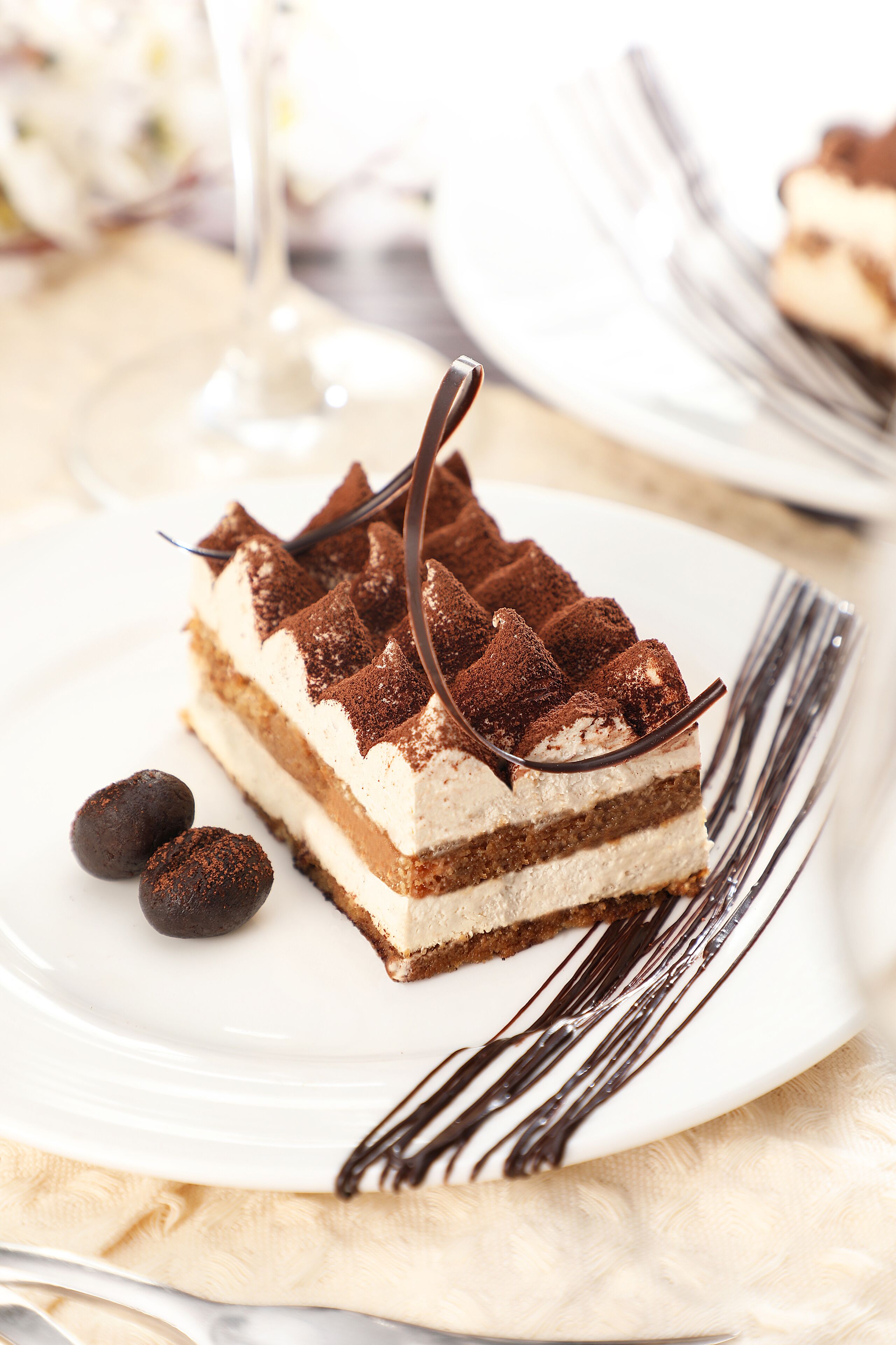 Una porción de postre en capas sobre un plato blanco, con un tenedor a un lado.