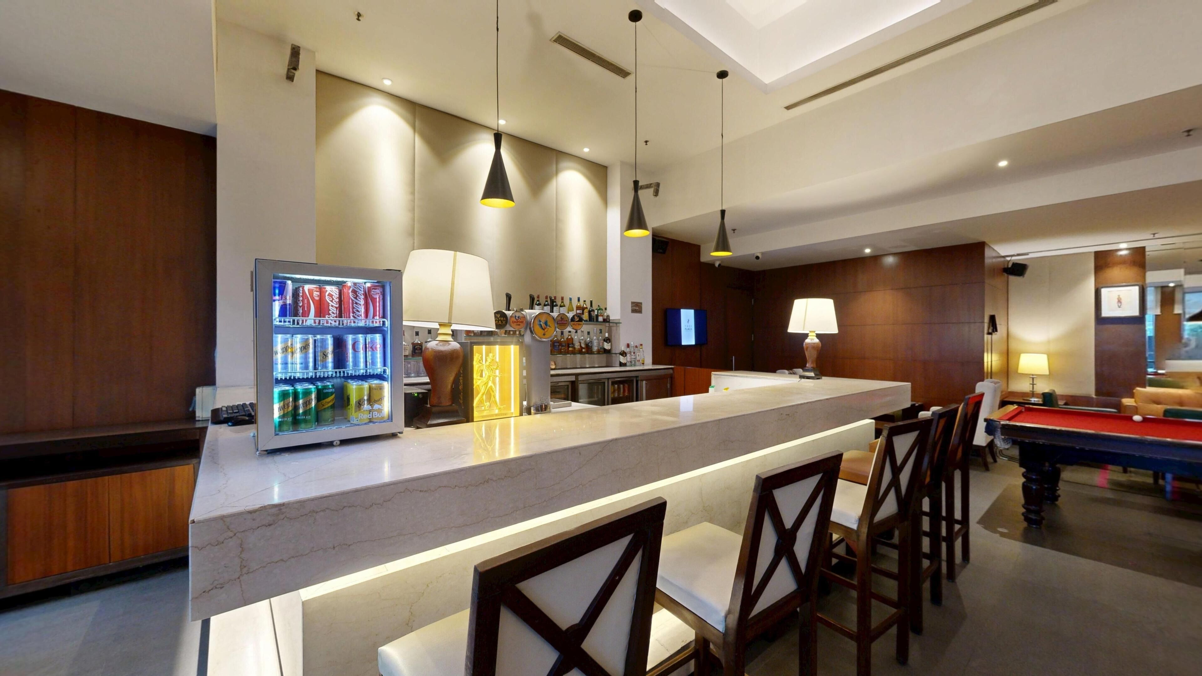A bar area with a minibar, pool table, and seating.