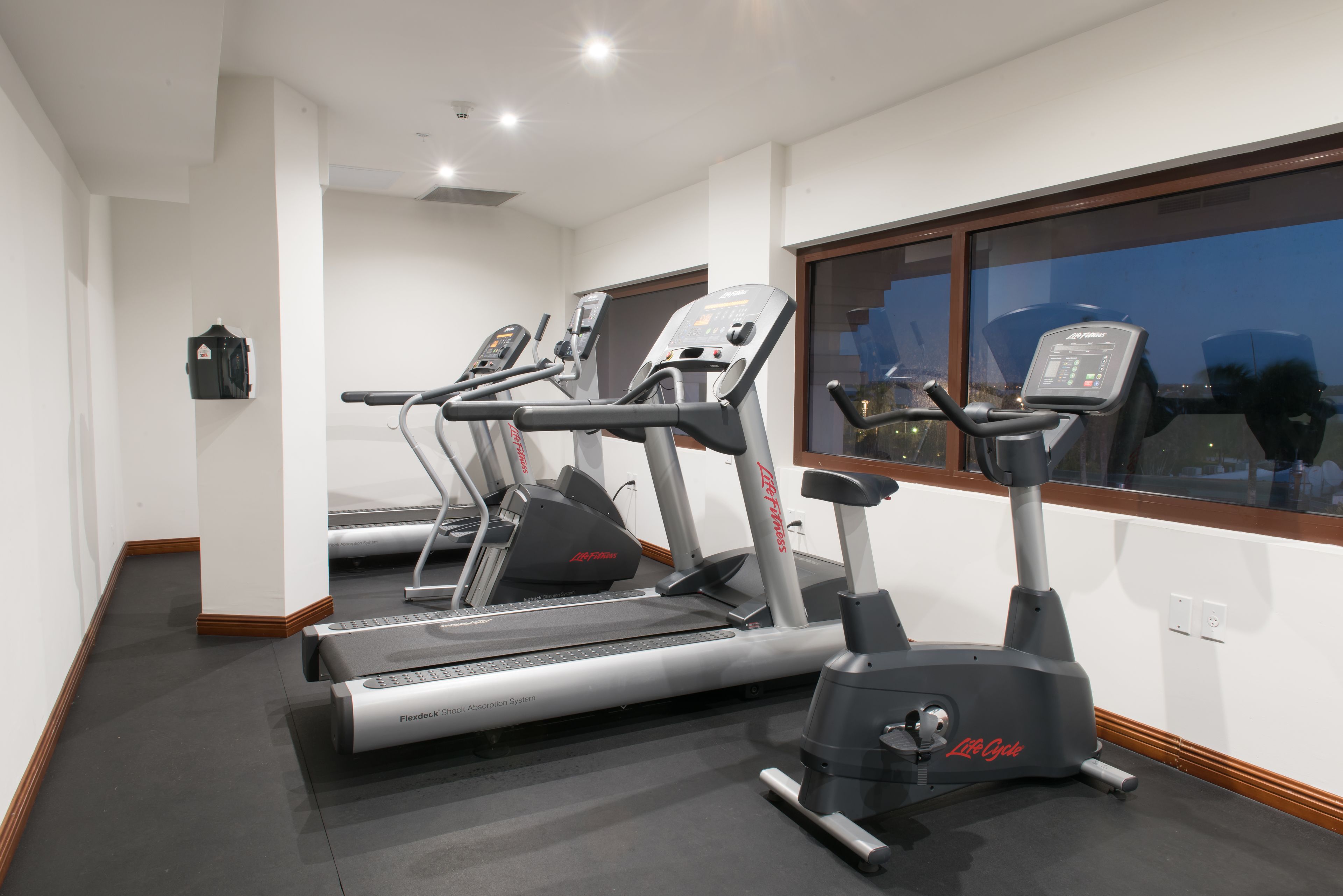 Ein Fitnessraum mit Laufbändern und einem Crosstrainer.