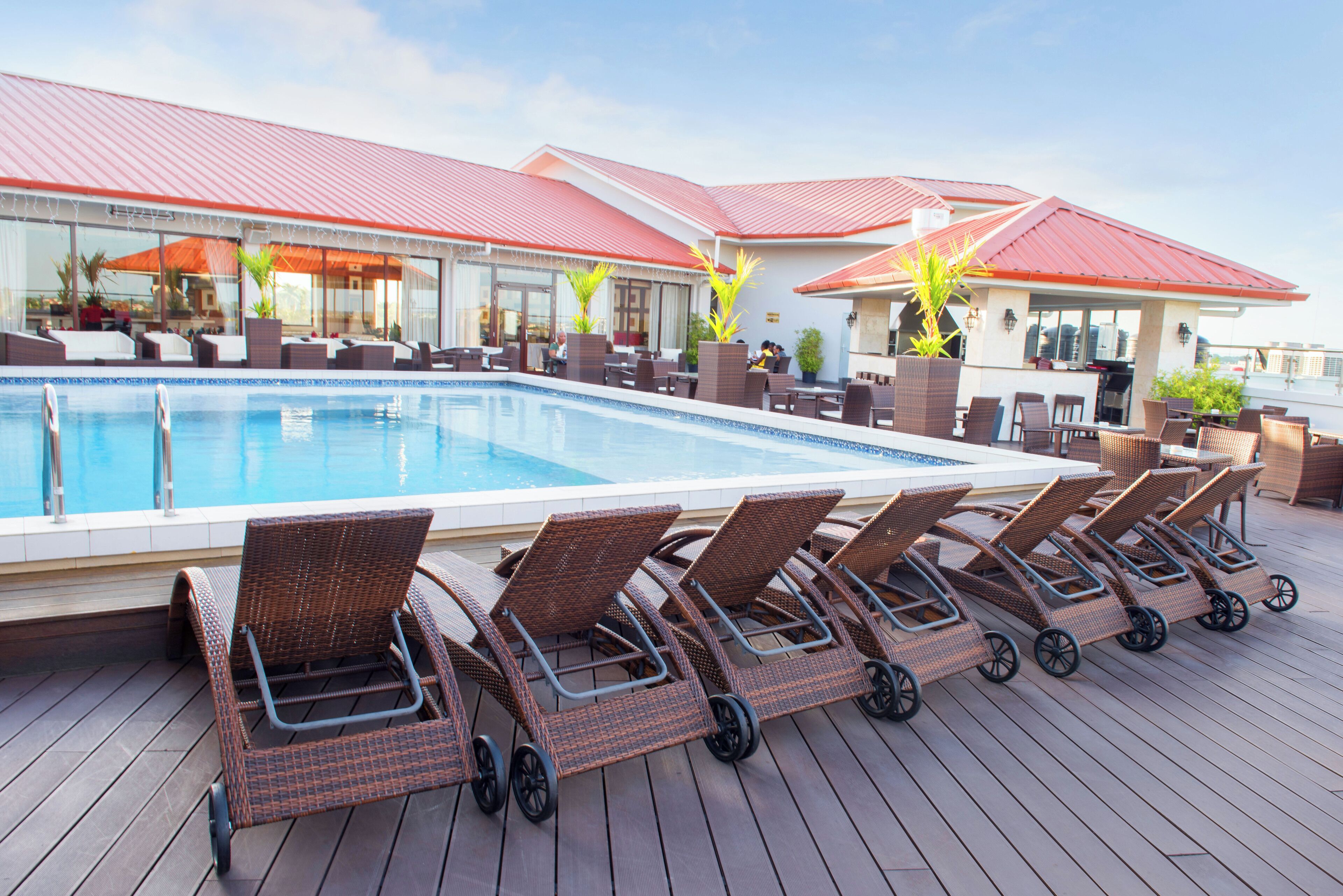 A poolside area with lounge chairs and a pool.
