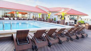 A poolside area with lounge chairs and a pool.