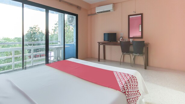 Ein Hotelzimmer mit einem großen Bett, einem Schreibtisch mit Computer, einem Stuhl und einem Balkon mit Blick.