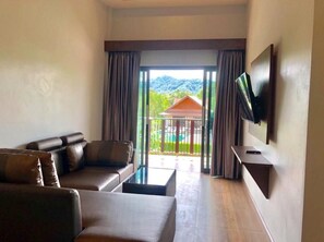 A modern living room with a sofa, a coffee table, and a TV mounted on the wall. - Oscar Villa Aonang Krabi (Krabi)