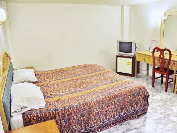 A hotel room with a bed, a television, a desk, and a chair. - Highfive Guest House (Pattaya)