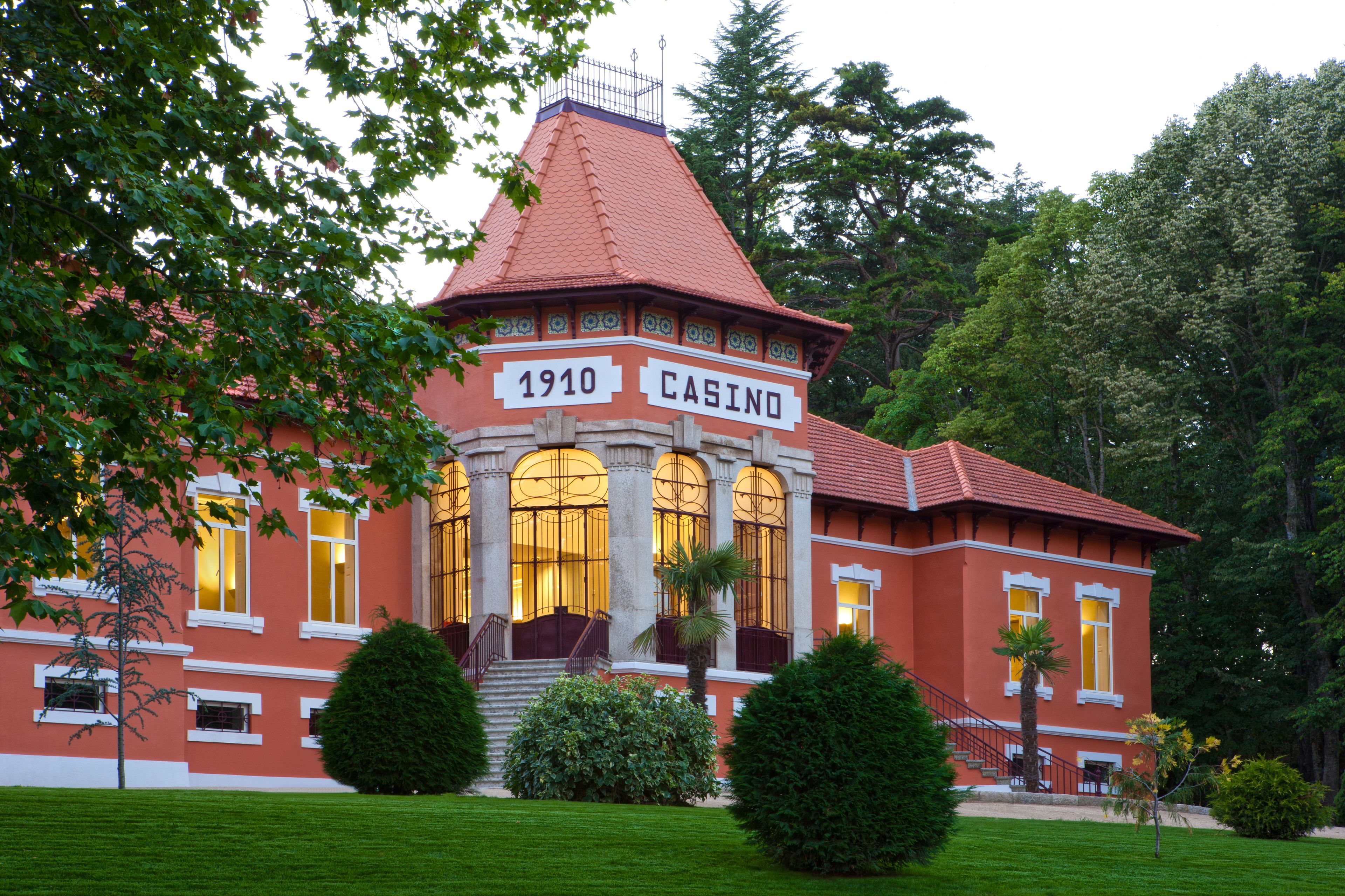 Un edificio histórico con fachada roja, ventanas arqueadas y una torre que dice "1910 CASINO".