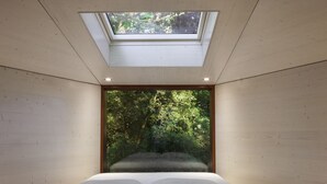 A bedroom with a skylight, a bed, and a large window with a forest view. - Pedras Salgadas Spa & Nature Park (Vila Pouca de Aguiar)