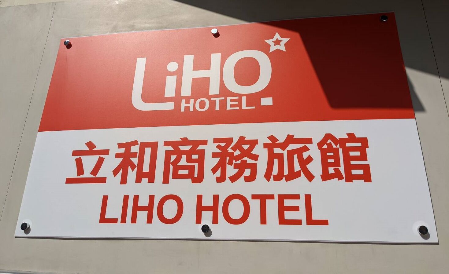 A sign for Liho Hotel with a red and white color scheme and Chinese characters.