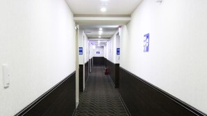A hotel hallway with directional signs, a fire extinguisher, and a carpeted floor. - LIHO Hotel - Tainan (Tainan)