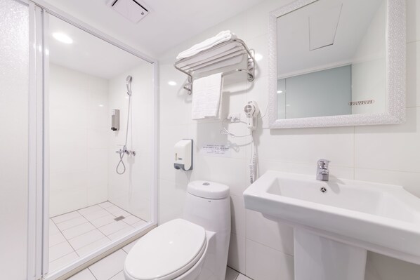 A modern bathroom with a glass shower enclosure, a white toilet, a sink, and a towel rack. - LIHO Hotel - Tainan (Tainan)