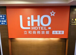 Schild für das LiHO Hotel mit Pfeilen und Schrift in Englisch und Chinesisch.