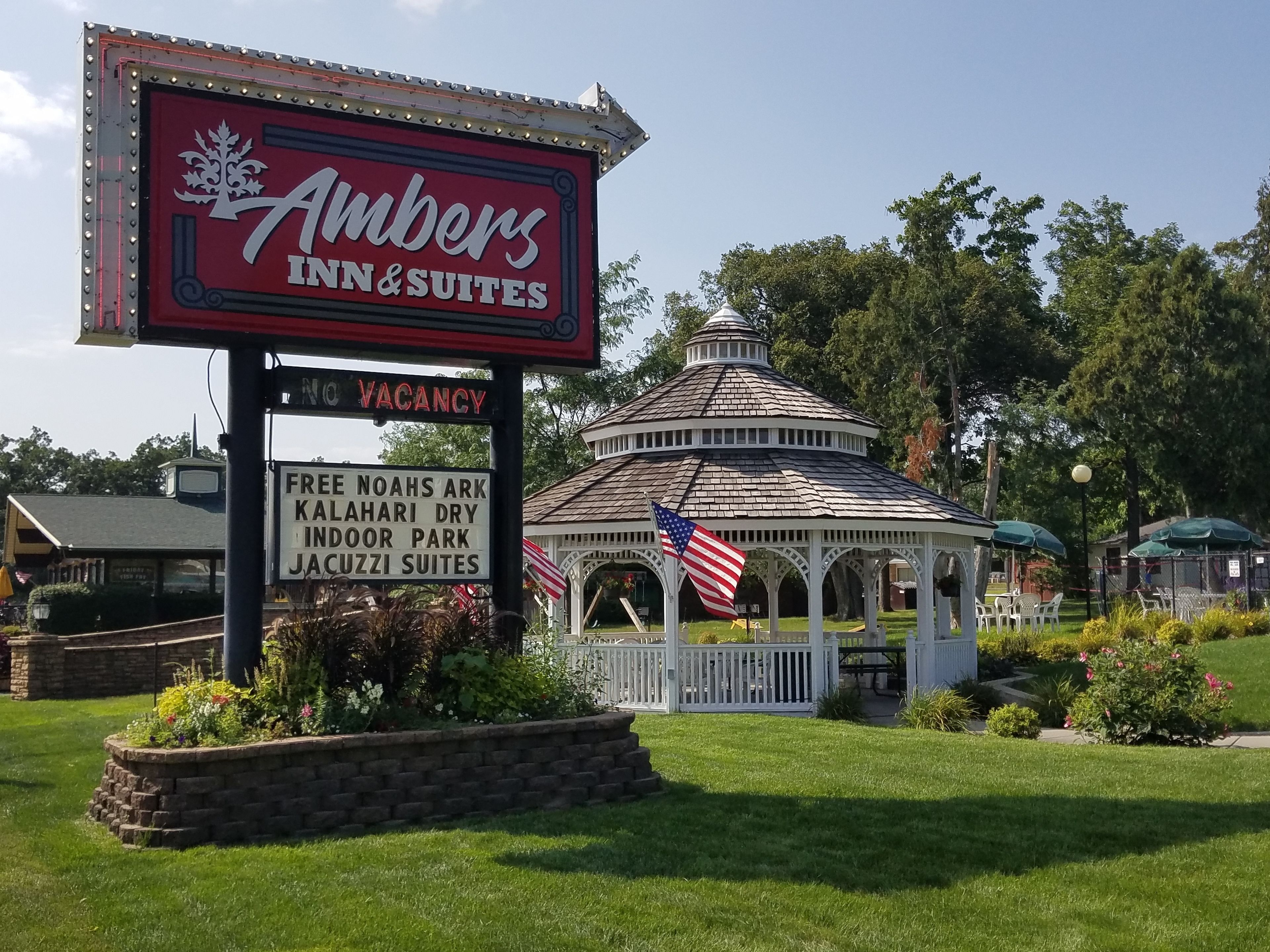 A sign for Amber's Inn & Suites with a vacancy notice, a gazebo, and a sign for Free Noahs Ark Kalahari Dry Indoor Park.