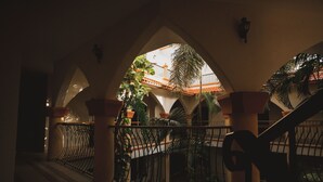 Une cour intérieure dotée d’un sol carrelé, d’une rambarde en métal et d’un escalier.