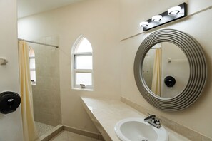 A bathroom with a shower, a sink, a mirror, and a window. - Sahara Hotel (Playa del Carmen)