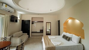Une chambre d’hôtel avec un lit, un canapé, une table et un téléviseur.