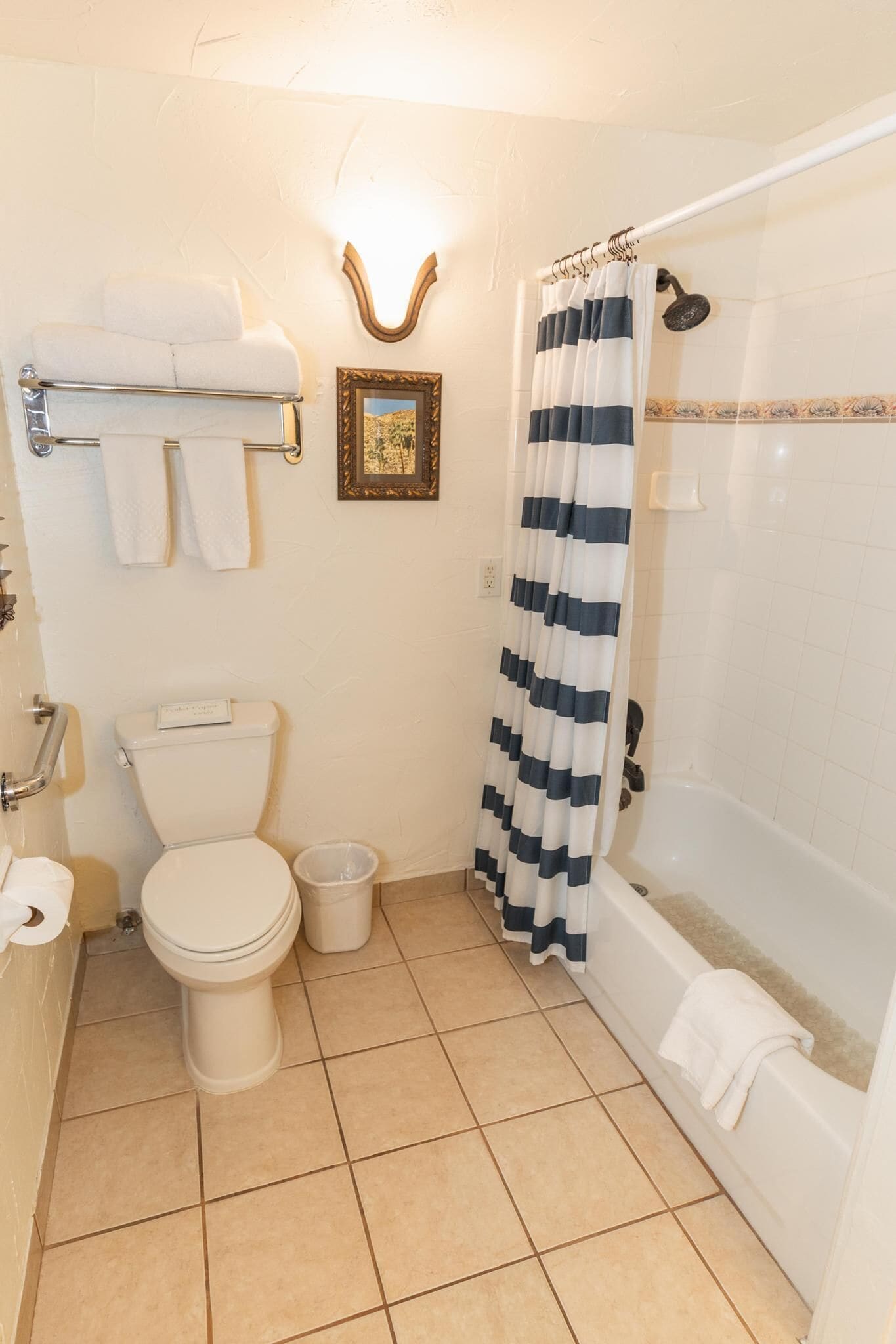 A bathroom with a toilet, a sink, a bathtub, and a shower curtain.