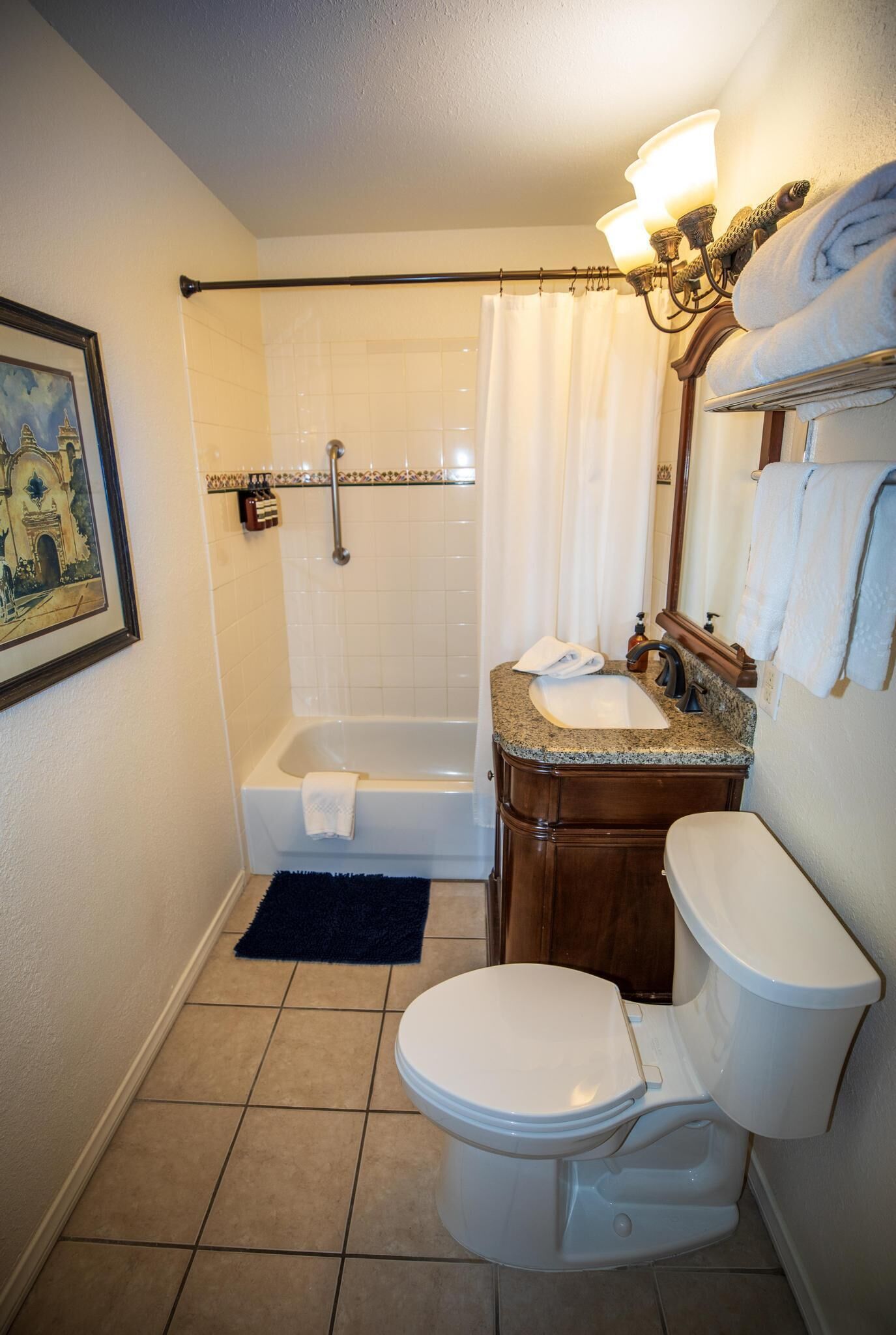 A bathroom with a bathtub, toilet, sink, and shower curtain.