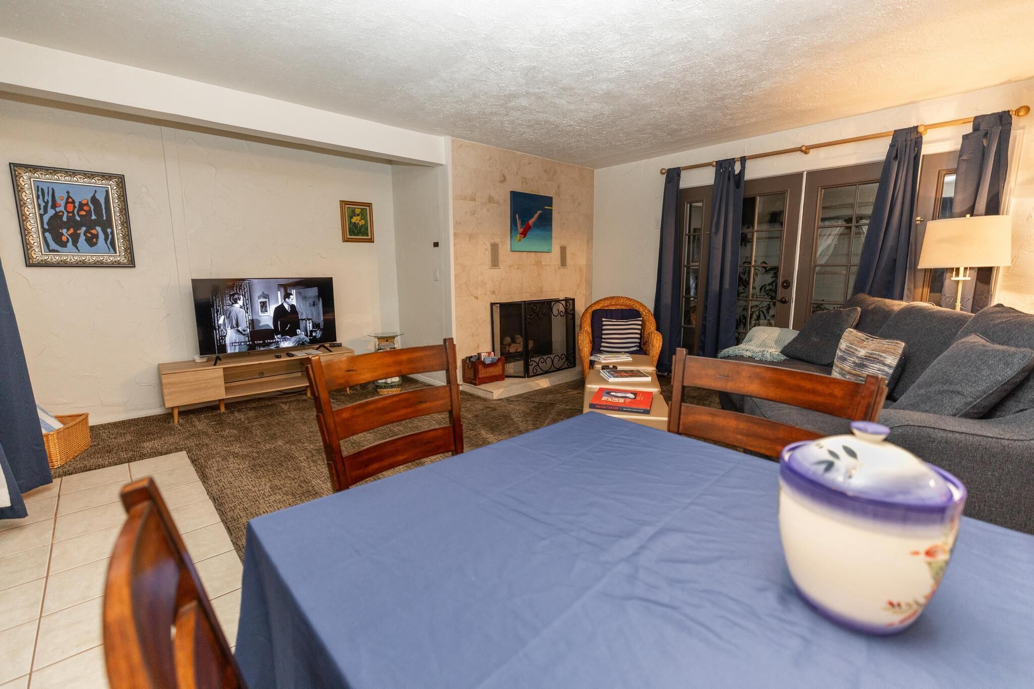 A living room with a television, a fireplace, a sofa, and a dining table.