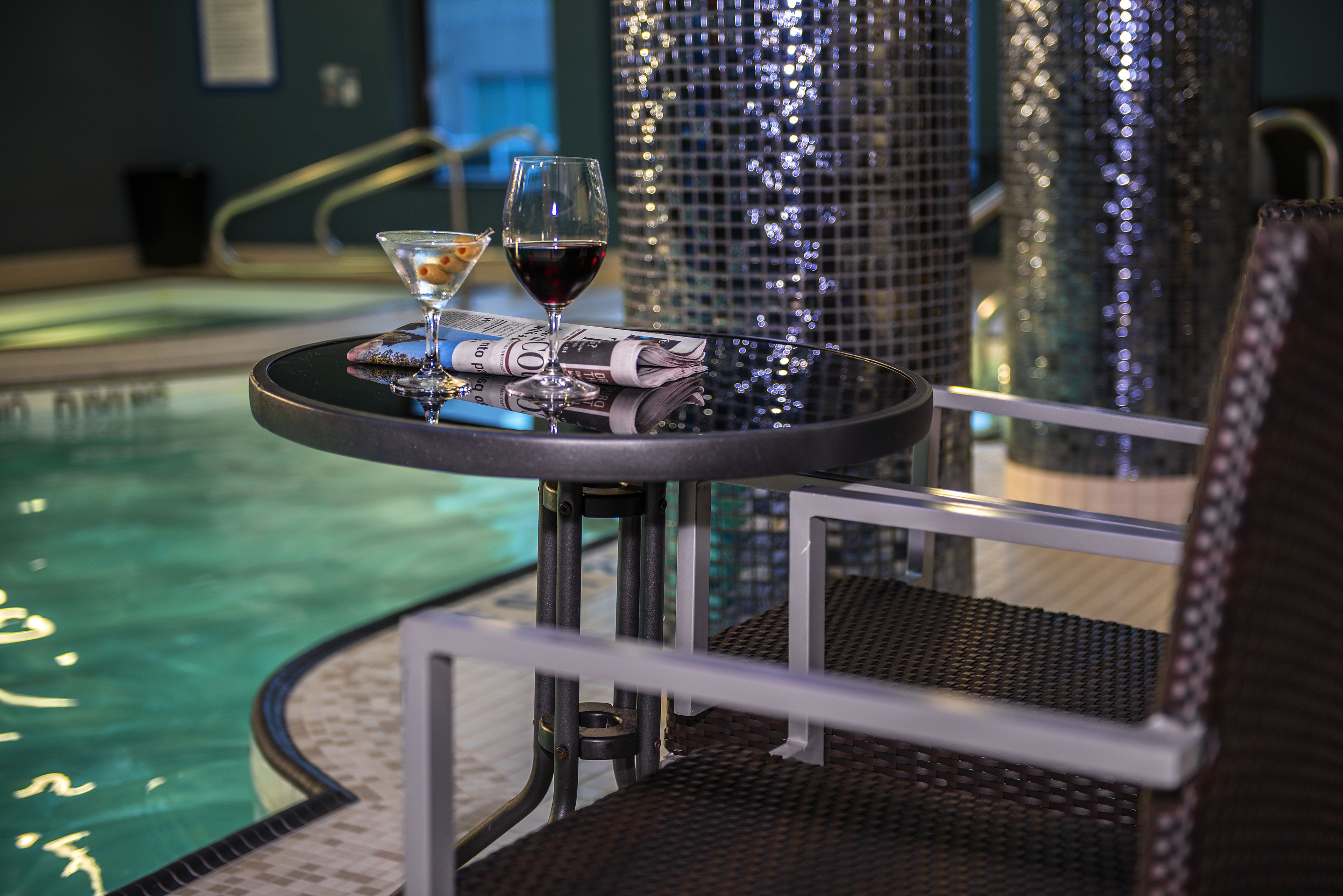 Een binnenzwembad, ligstoelen bij het zwembad