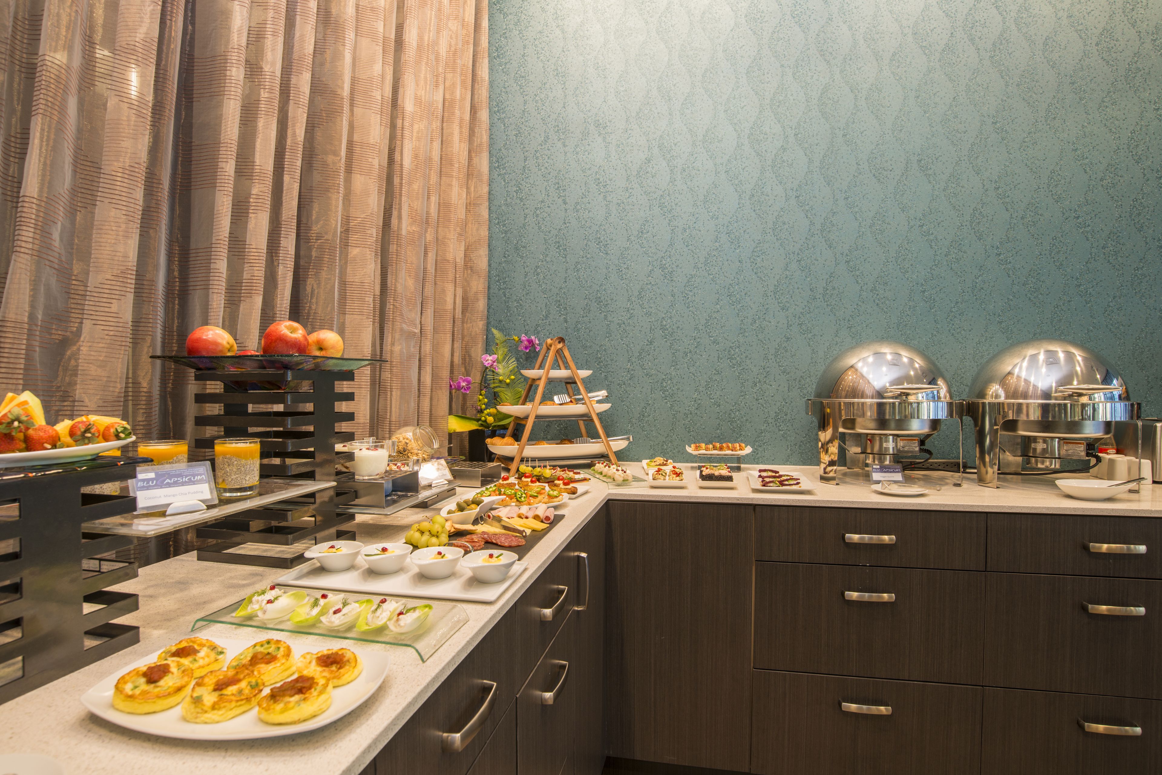 Een buffet met diverse soorten eten, zoals fruit, kazen en gebak.