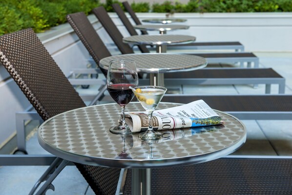 A table with a newspaper, a martini glass, and a wine glass. - Hotel Blu Vancouver (Vancouver)