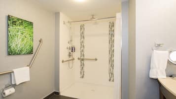 A modern bathroom with a shower, toilet, and sink.