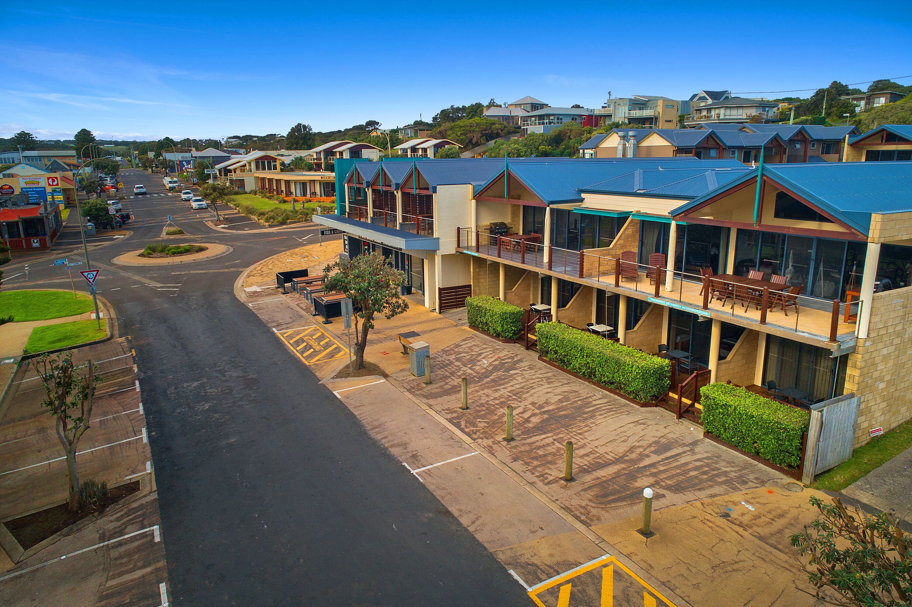 A hotel with a central courtyard, multiple balconies, and a parking area.