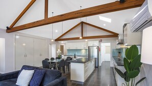Una cocina moderna con una isla central, armarios blancos y un refrigerador de acero inoxidable.