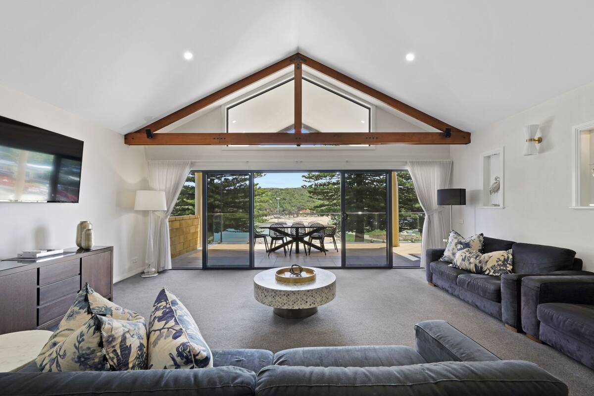 A spacious living room with a large window, a round coffee table, and a sofa.