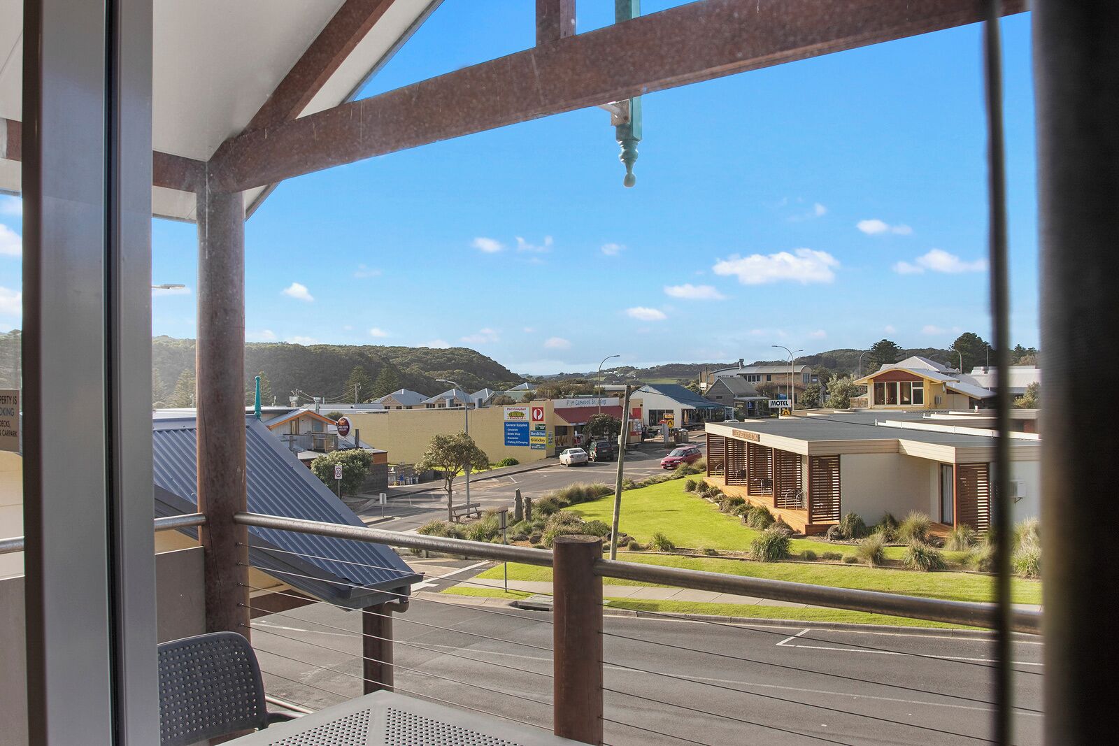 Vista da janela com vista para uma rua repleta de edifícios, incluindo um motel e uma área comercial.