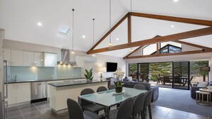 Una cocina moderna con comedor, ventanas amplias y vistas al exterior.