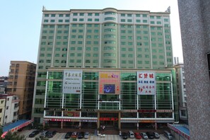 A multi-story hotel with large windows and several signs advertising various services. - BORRMAN Hotel (Guangzhou)