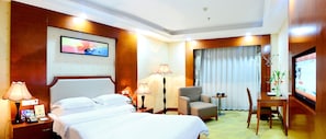A hotel room with a bed, bedside lamps, a desk with a chair, a television, and a window with curtains. - BORRMAN Hotel (Guangzhou)
