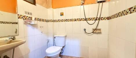 A bathroom with a toilet, sink, and shower.