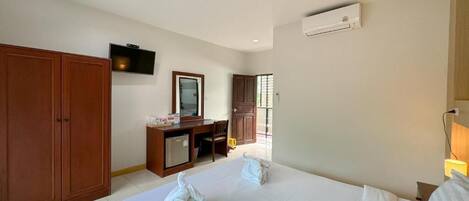 A hotel room with a bed, a desk, a TV, and a wardrobe.