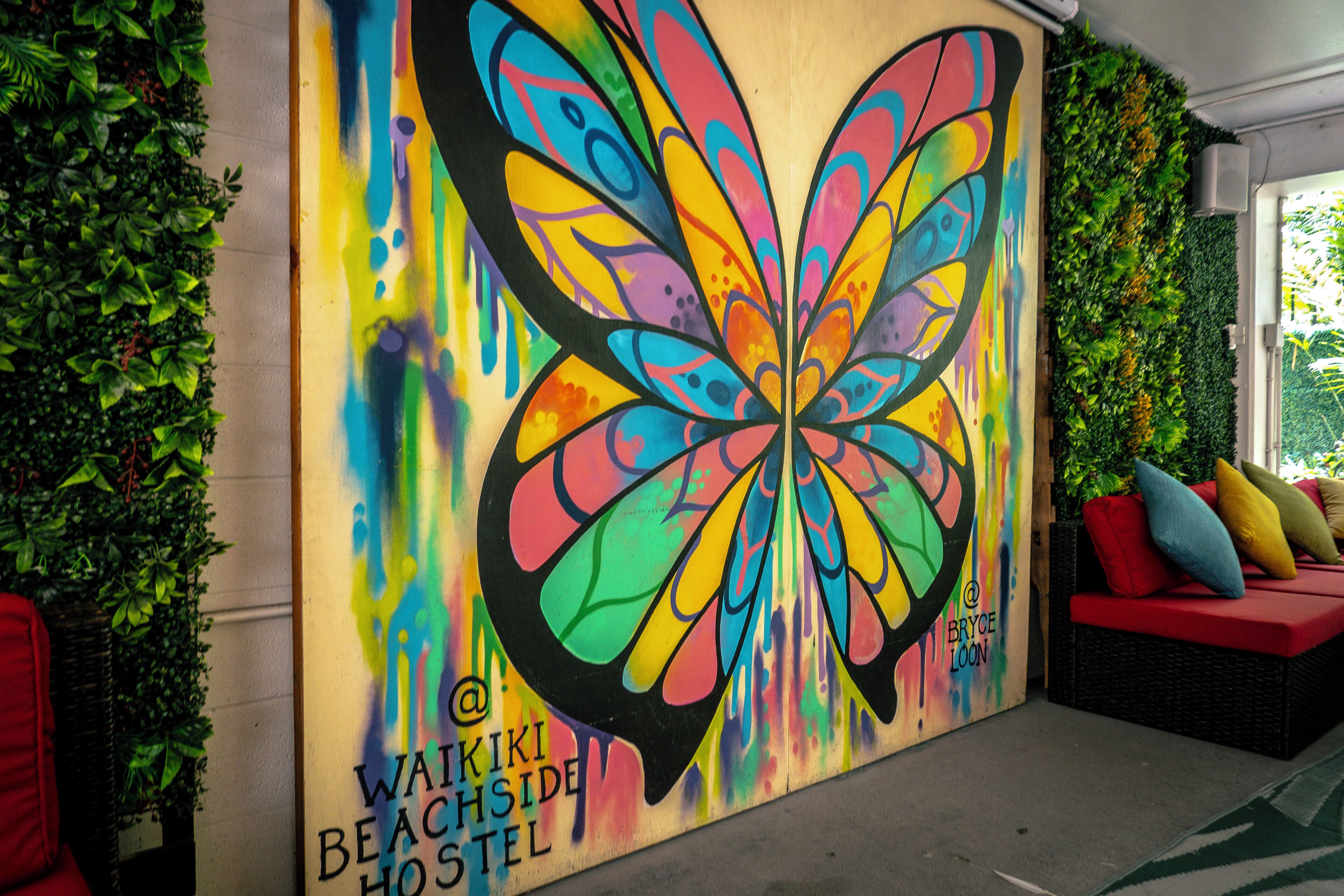 Un mural vibrante con mariposas en Waikiki Beachside Hostel.
