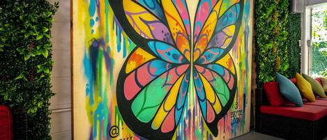 Un mural vibrante con mariposas en Waikiki Beachside Hostel.