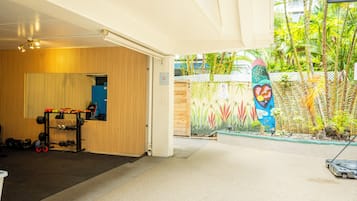 An indoor gym with a wooden wall, a weight rack, and a mural.
