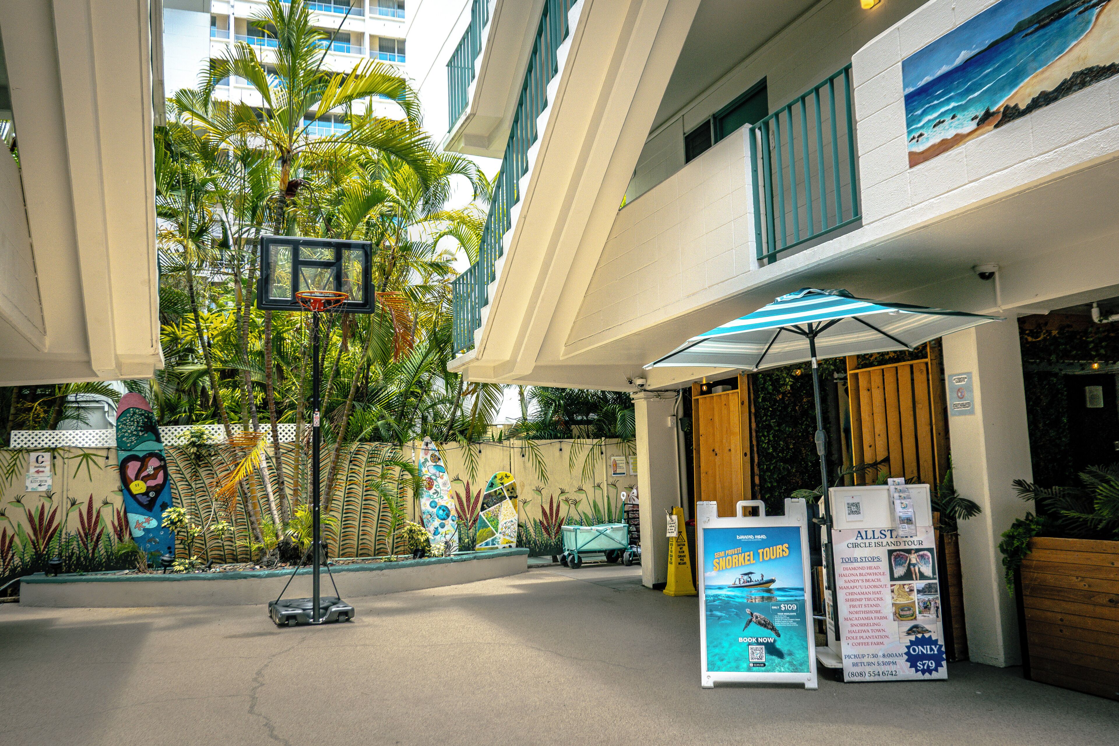 A basketball hoop, a beach-themed mural, and a sign for Circle Island tours.