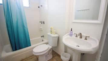 A bathroom with a bathtub, toilet, and sink.