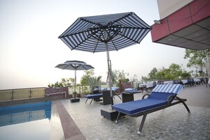 A poolside area with lounge chairs and umbrellas.