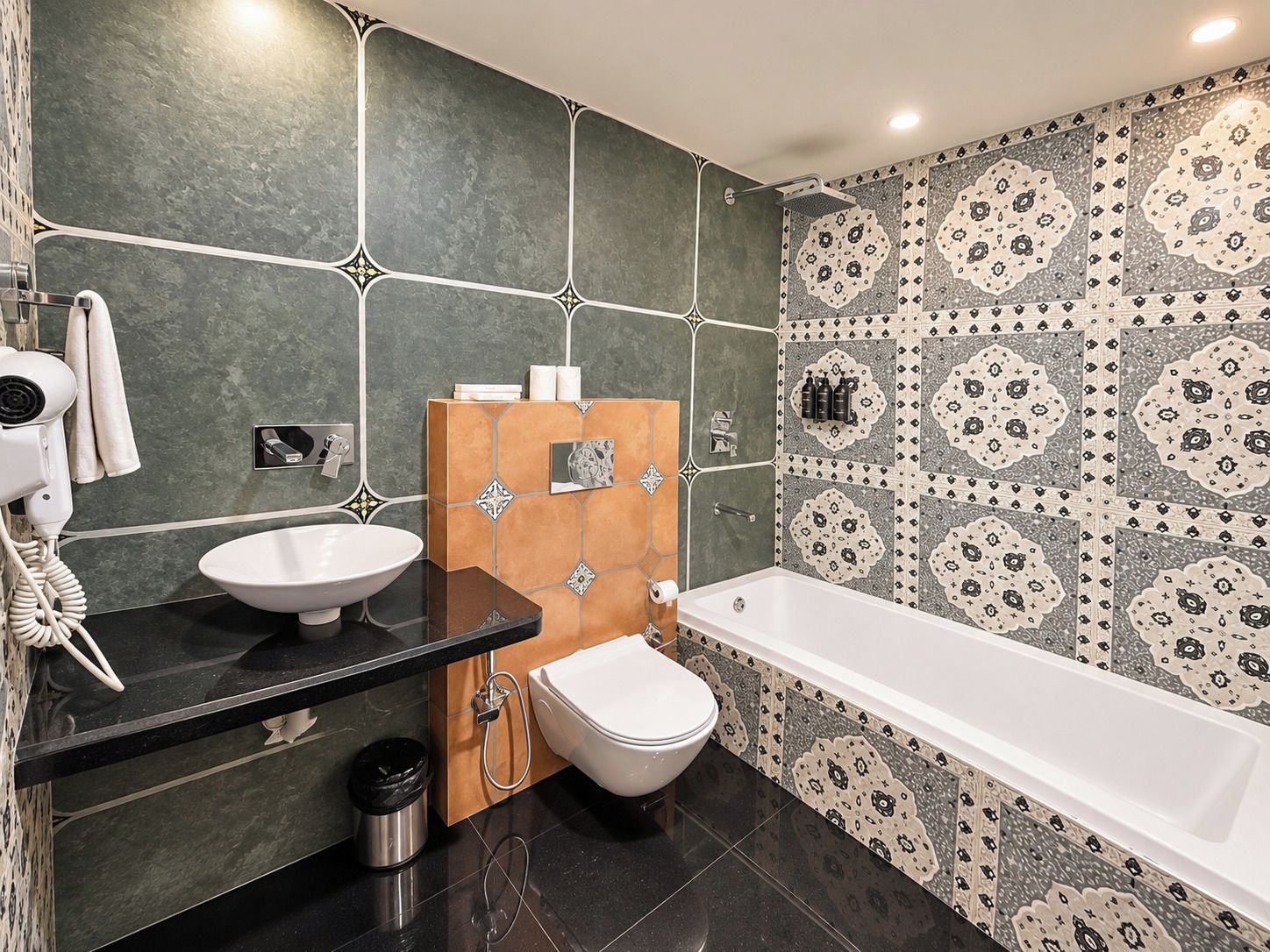 Un baño con lavamanos, inodoro y bañera, con baldosas estampadas y un diseño moderno.