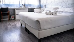 Een moderne hotelkamer met een groot bed, een bureau en een stoel.