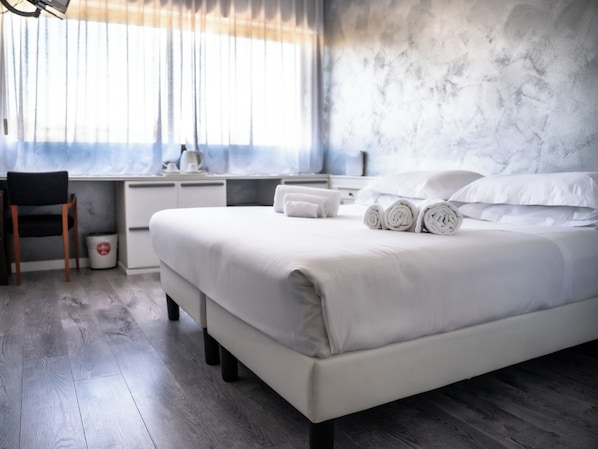 Una habitación de hotel moderna con una cama grande, un escritorio y una silla.