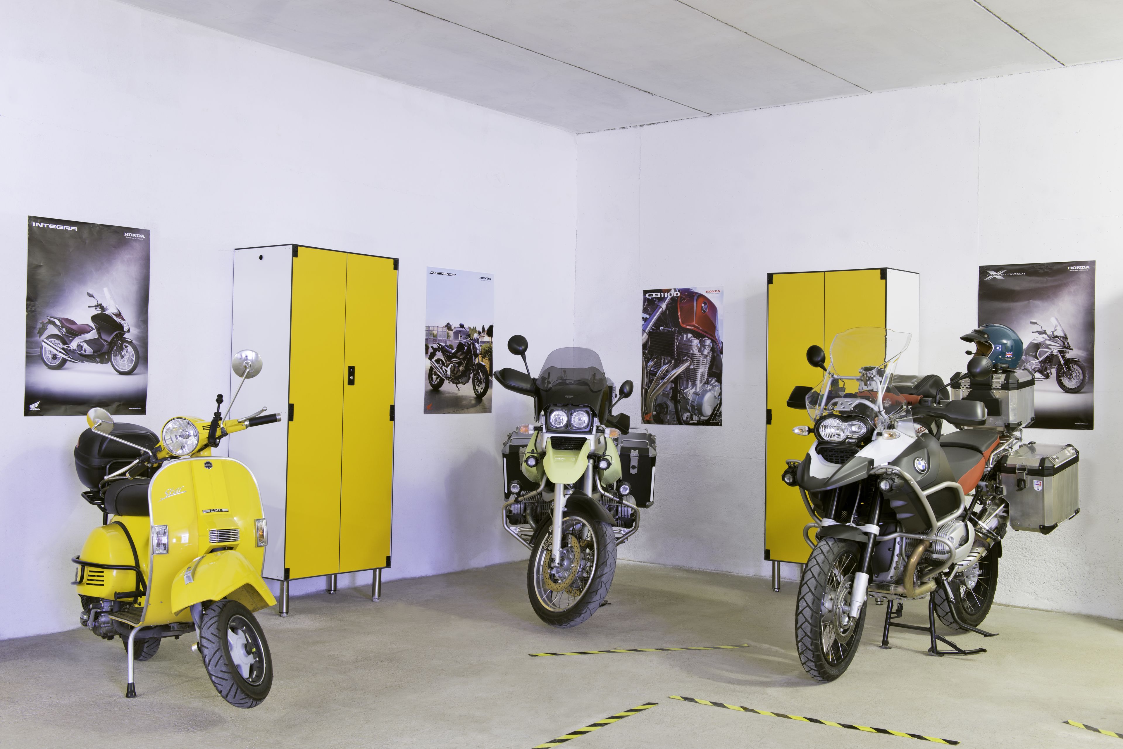 Ein Motorradsalon mit drei Motorrädern und gelben Schließfächern.