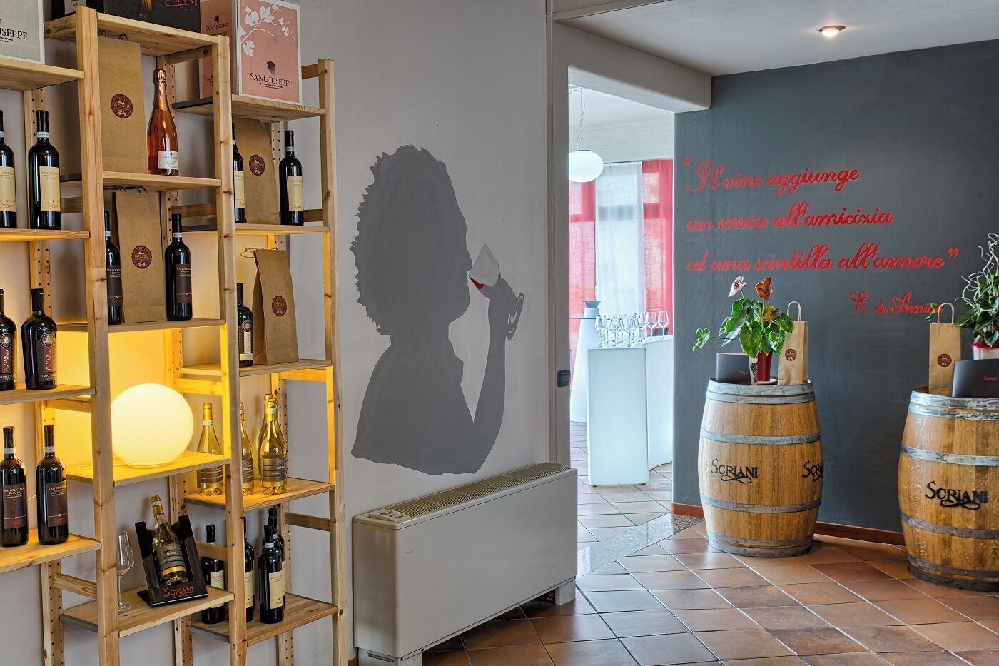 Een wijnkelder met wijnflessen op rekken, een silhouetkunstwerk en houten vaten.