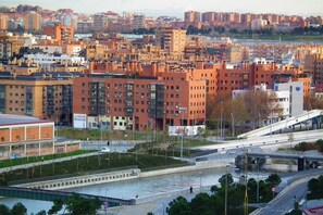 Un paysage urbain avec une rivière, des ponts et un mélange de bâtiments résidentiels et commerciaux.