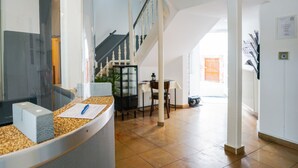Una zona de recepción con mostrador, escalera y comedor.